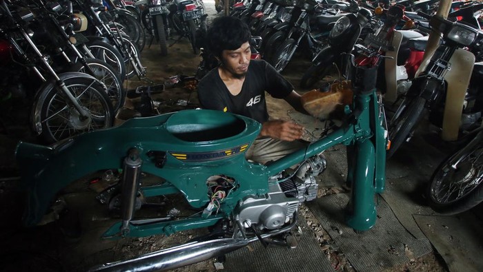 Pekerja melakukan penggantian suku cadang motor antik yang sedang direstorasi di Galeri Motor Jadul Pondok Cabe, Tangerang, Selatan, Banten, Selasa (28/12/2021). Motor antik tahun 1950-an hingga 1980-an yang sudah direstorasi itu kemudian dijual dengan harga Rp3 juta hingga Rp150 juta. ANTARA FOTO/Muhammad Iqbal/tom.