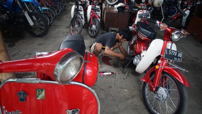 Pekerja melakukan penggantian suku cadang motor antik yang sedang direstorasi di Galeri Motor Jadul Pondok Cabe, Tangerang, Selatan, Banten, Selasa (28/12/2021). Motor antik tahun 1950-an hingga 1980-an yang sudah direstorasi itu kemudian dijual dengan harga Rp3 juta hingga Rp150 juta. ANTARA FOTO/Muhammad Iqbal/tom.