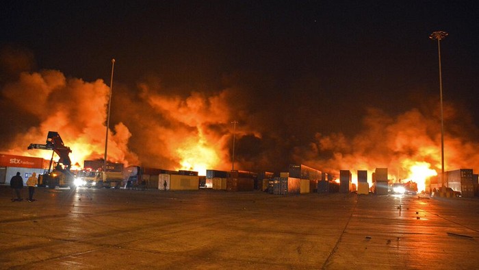 Pelabuhan Latakia di Suriah Porak Poranda Digempur Israel Dalam foto yang dirilis oleh kantor berita resmi Suriah SANA, api muncul dari kontainer di lokasi serangan rudal, di pelabuhan kota pesisir Latakia, Suriah, Selasa pagi, 28 Desember 2021. Rudal Israel ditembakkan dari Mediterania menyerang pelabuhan Latakia di Suriah Selasa pagi, memicu kebakaran di terminal peti kemas, media pemerintah Suriah melaporkan, dalam serangan kedua di fasilitas vital bulan ini. (SANA melalui AP)