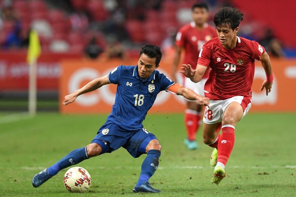 Thailand's Chanathip Songkrasin (L) fights for the ball with Indonesia's Alfeandra Dewangga Santosa during the first leg of the AFF Suzuki Cup 2020 football final match between Indonesia and Thailand at the National Stadium in Singapore on December 29, 2021. (Photo by Roslan RAHMAN / AFP)