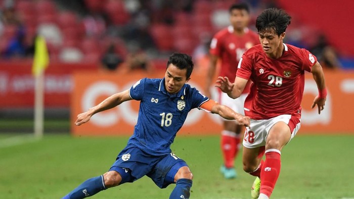 Thailands Chanathip Songkrasin (L) fights for the ball with Indonesias Alfeandra Dewangga Santosa during the first leg of the AFF Suzuki Cup 2020 football final match between Indonesia and Thailand at the National Stadium in Singapore on December 29, 2021. (Photo by Roslan RAHMAN / AFP)