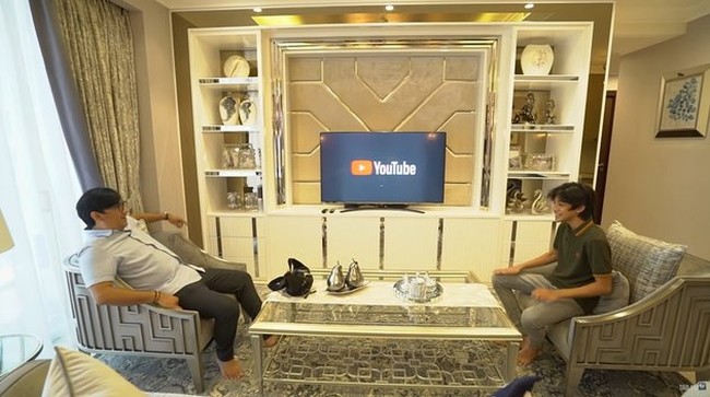Di samping meja makan terdapat ruang TV yang dilengkapi dengan meja dan sofa. Untuk mempercantik, terdapat beberapa pajangan yang diletakkan di meja TV tersebut. Foto: YouTube/Taulany TV