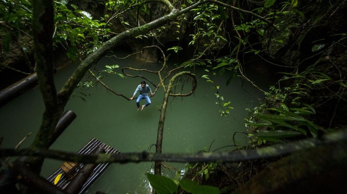 GEOTOURISM GEOPARK MERATUS Pengelola wisata Rosyadi menggunakan rakit bambu di Geotourism Geopark Meratus Goa Limbuhang Haliau di Desa Haliau, Kabupaten Hulu Sungai Tengah, Kalimantan Selatan, Rabu (29/12/2021). Wisata alam yang dikelola oleh Pokdarwis Mancakup itu menjadi salah satu dari 34 situs warisan geologi yang diusulkan oleh badan pengelola Geopark Meratus ke UNESCO Global Geopark (UGG). ANTARA FOTO/Bayu Pratama S/aww.