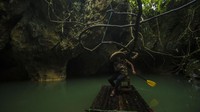 Pengelola wisata Rosyadi menggunakan rakit bambu di Geotourism Geopark Meratus Goa Limbuhang Haliau di Desa Haliau, Kabupaten Hulu Sungai Tengah, Kalimantan Selatan.