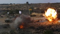 Militan Palestina menembaki replika tank selama latihan militer.
