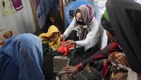 Seorang perawat memeriksa berat badan seorang anak di klinik darurat yang diselenggarakan oleh World Vision di sebuah pemukiman dekat Herat, Afghanistan. Malnutrisi mengintai yang paling rentan.