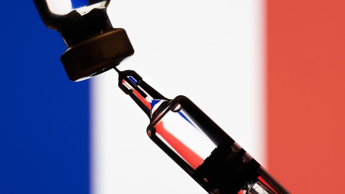Covid-19 vaccine  and  vaccine injector in front of the France flag