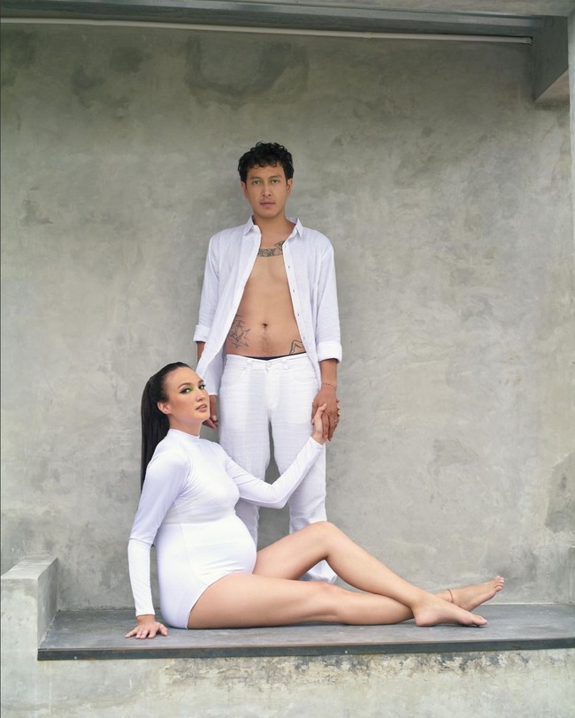 Nadine Chandrawinata dan Dimas Anggara mengenakan busana berwarna senada, serba putih. Konsep pemotretan kehamilan minimalis dan simpel. Foto: Instagram/@nadinelist