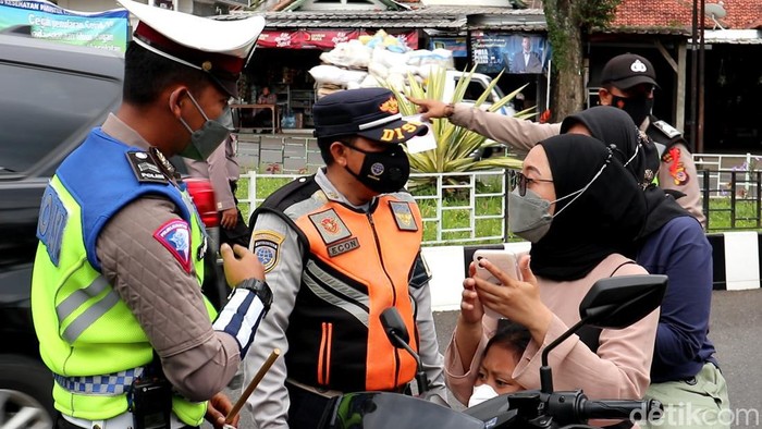 Petugas gabungan melakukan pengecekan bukti vaksinasi pengendaran di Kuningan