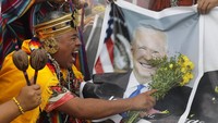 Dukun memegang foto Presiden AS Joe Biden selama ritual akhir tahun di mana mereka memprediksi masalah politik dan sosial yang diperkirakan akan terjadi tahun depan di Lima.