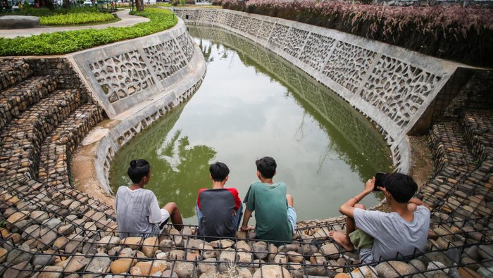 TAMAN BIO TRANS JAKARTA Warga bersantai di Taman Bio Trans, Cempaka Putih, Jakarta, Kamis (30/12/2021). Taman Bio Trans tersebut sebagai bentuk upaya Pemprov DKI untuk mewujudkan kota ramah lingkungan yang berfungsi menjadi taman terbuka dan sebagai pengendali banjir ketika terjadi peningkatan volume air di saluran sungai. ANTARA FOTO/Rivan Awal Lingga/YU