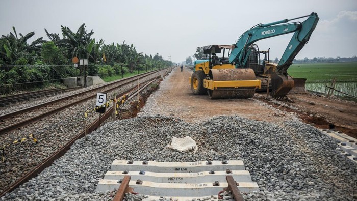 177,26 KM Jalur Kereta Api Dibangun Selama 2021 Petugas mengoperasikan alat berat untuk menyelesaikan proyek jalur ganda kereta api Cicalengka-Kiaracondong di Cimekar, Bandung, Jawa Barat, Jumat (31/12/2021). Direktorat Jenderal Perkeretaapian (DJKA) Kementerian Perhubungan mencatat selama tahun 2021 DJKA telah membangun setidaknya 177,26 kilometer jalur kereta api di sejumlah daerah di Indonesia. ANTARA FOTO/Raisan Al Farisi/nym.