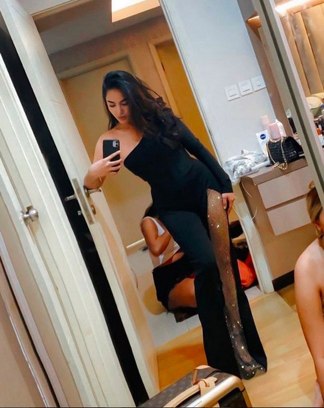 Saat harus tampil formal, Cassandra Angelie tetap mengandalkan gaun yang mengakomodasi keseksiannya. Seperti gaun hitam dengan bahu asimetris yang memiliki belahan rok tinggi ini. (Foto: Instagram/@cassangelie)