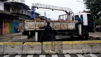 Petugas Dishub memasang beton guna menutup akses Jalan Haji Ung, Kemayoran, Jakarta, Jumat (31/12/2021).