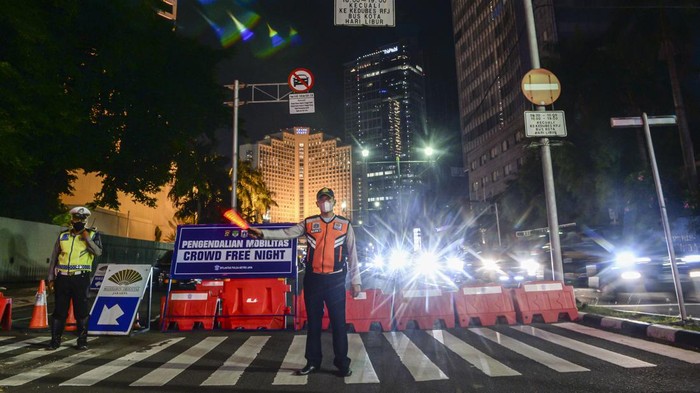 Petugas gabungan menutup akses jalan menuju Bundaran Hotel Indonesia dari Jalan Imam Bonjol, Jakarta, Jumat (31/12/2021). Polda Metro Jaya memberlakukan pengendalian mobilitas Crowd Free Night (malam bebas keramaian) pada malam tahun baru 2022 yang berlangsung mulai pukul 22.00 - 04.00 WIB. ANTARA FOTO/M Risyal Hidayat/foc.