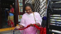 Calon pembeli melihat-lihat koleksi tenun sutra tradisional di Hyderabad, India bagian tengah.