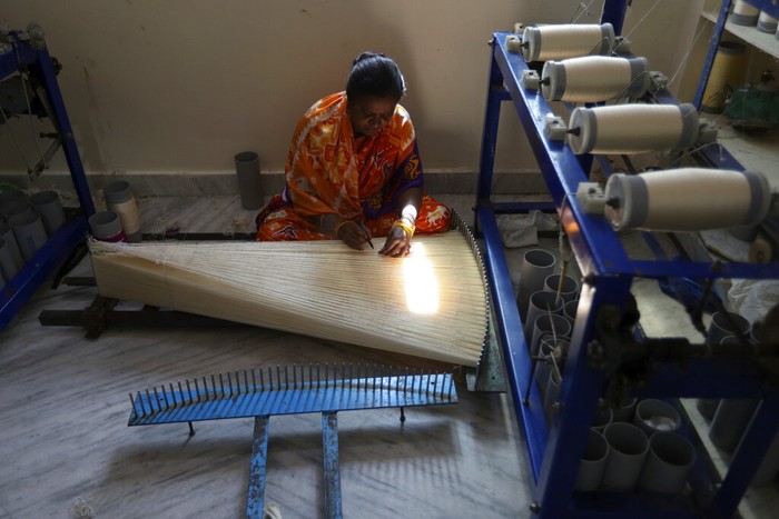 An Indian weaver prepares silk yarn for dyeing at a small scale handloom factory on the outskirts of Hyderabad, India, Thursday, Dec. 30, 2021. Handloom is one of the largest source of employment in India providing livelihood to more than four million people. (AP Photo/Mahesh Kumar A.)