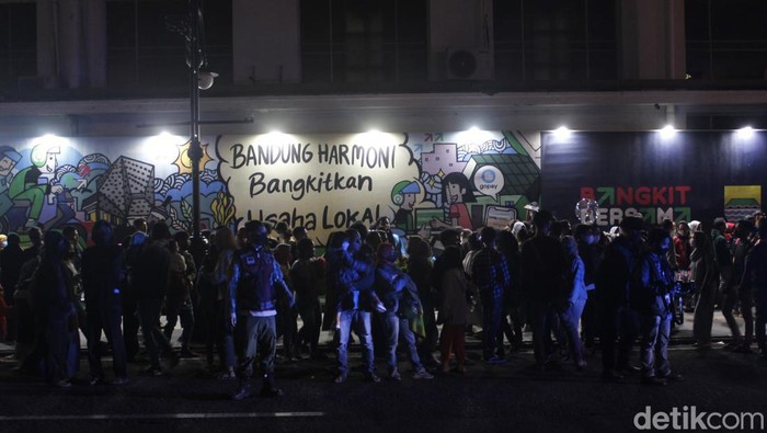 Alun-alun Kota Bandung di Jalan Asia Afrika menjadi lautan manusia jelang malam pergantian tahun baru 2022, Jumat (31/12/2021). Ribuan manusia tumplek memadati ruas-ruas jalan mulai dari Gedung Merdeka hingga sekitar Masjid Raya Bandung.