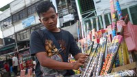 Seorang pedagang tengah merapikan dagangannya. Pedagang mengaku bahwa penjualan kembang api pada tahun ini lebih baik jika dibandingkan dengan tahun sebelumnya. 