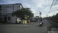 Jalan yang diperlebar itu terlihat dibeton. Tampak ada trotoar di sisi kanan dan kiri jalan.