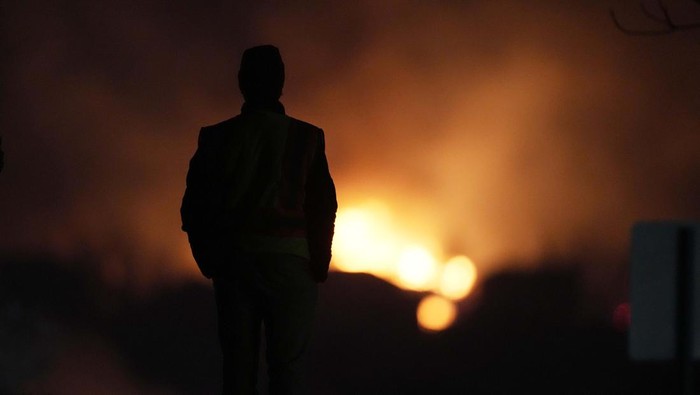 Potret Kebakaran Hutan yang Hanguskan Ratusan Rumah di Colorado A person stands on a hillside, watching as homes are consumed by wildfires Thursday, Dec. 30, 2021, in Superior, Colo. (AP Photo/David Zalubowski)