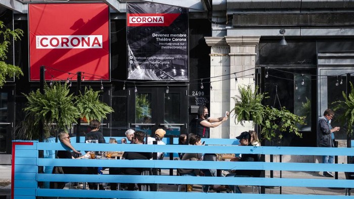 Patrons enjoy an evening drink and dinner on the terrace of the Burgundy Lion as restaurants start reopening outdoor dining in Montreal, Canada on May 28, 2021. - Restaurants in Montreal have been closed for seating since October 2020, although many did have the option for delivery. The soft re-opening of terraces throughout the city marks the beginning of the deconfinement plan by the Legault Government, with restaurants expected to open for indoor seating to the public on June 7, 2021. (Photo by Andrej Ivanov / AFP)