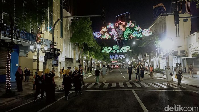 Tak Ada Kumpul-kumpul, Petugas Bubarkan Warga di Tunjungan Romansa Surabaya Menjelang pergantian tahun baru, warga Surabaya memenuhi Jalan Tunjungan. Namun warga harus pulang lebih awal, sebab Pemkot mensterilkan lokasi lebih pada pukul 21.00 WIB, Jumat, (31/12/2021).