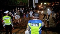 Polisi membubarkan warga yang masih melakukan aktivitas di luar rumah melebihi batas waktu yang ditentukan di Pantai Kuta, Badung, Bali, Sabtu (1/1/2022) dini hari. Petugas gabungan membubarkan aktivitas masyarakat di berbagai titik di kawasan wisata Kuta untuk mengantisipasi keramaian dan kerumunan masyarakat saat perayaan pergantian tahun baru. ANTARA FOTO/Fikri Yusuf