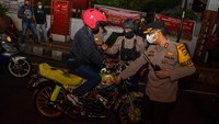 Wakapolresta Ambon dan Pulau Lease AKBP Heri Budianto (kanan) mengehantikan pengendara motor saat operasi pengamanan malam tahun baru di Kota Ambon, Provinsi Maluku, Jumat (31/12/2021). Pasukan gabungan TNI-Polri di Ambon melakukan penyekatan jalan dan langsung menindak warga yang tidak menerapkan protokol kesehatan pada operasi pengamanan malam tahun baru 2022. ANTARA/FB Anggoro