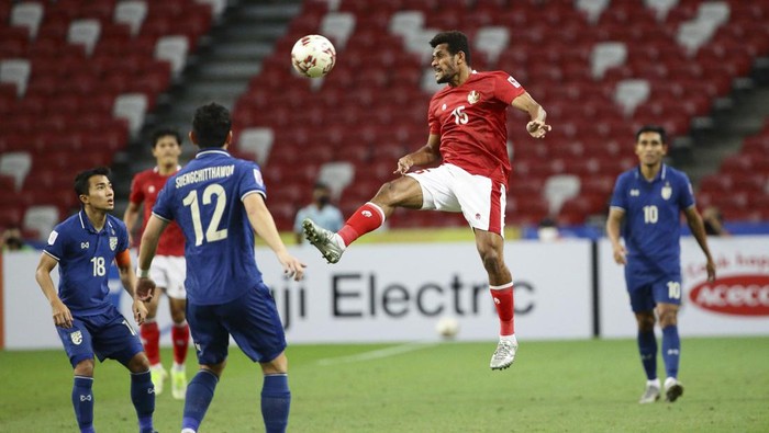 Ricky Richardo Kambuaya of Indonesia, second right, jumps for the ball during the AFF Suzuki Cup 2020 final second leg match between Thailand and Indonesia in Singapore, Saturday, Jan. 1, 2022. (AP Photo/Suhaimi Abdullah)