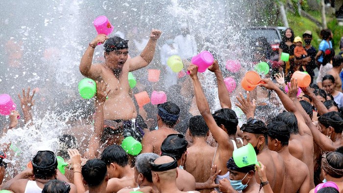 TRADISI PERANG AIR DI BALI Sejumlah warga saling menyiramkan air saat Tradisi Perang Air dalam rangkaian Festival Air Suwat di Desa Suwat, Gianyar, Bali, Sabtu (1/1/2022). Tradisi itu dilakukan warga setempat untuk membersihkan diri secara lahir dan batin serta memperkuat rasa persaudaraan sekaligus menjadi atraksi wisata bagi wisatawan. ANTARA FOTO/Fikri Yusuf/rwa.
