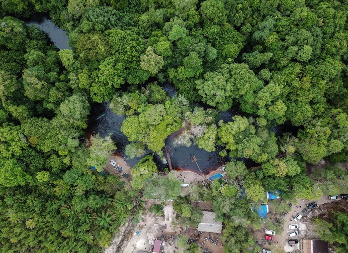 Sejumlah wisatawan bermain air di kawasan pemandian air gambut Danum Bahandang Tangkiling di Palangkaraya, Kalimantan Tengah, Minggu (2/1/2022). Objek wisata yang menyuguhkan ekosistem air hitam murni dari tanah dan akar-akar lahan gambut tersebut menjadi salah satu destinasi wisata favorit warga untuk mengisi liburan tahun baru. ANTARA FOTO/Makna Zaezar/wsj.