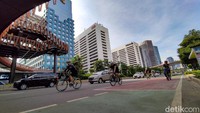 Warga berolahraga di kawasan Jalan Sudirman, Jakarta, Minggu (2/1/2022). 