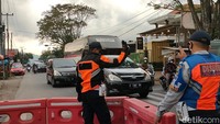 Di kawasan ini, petugas kepolisian dan Dinas Perhubungan bersiaga menguras kendaraan yang menumpuk. 