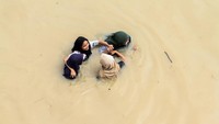 Beberapa warga bahkan nekat menembus banjir yang menerjang.