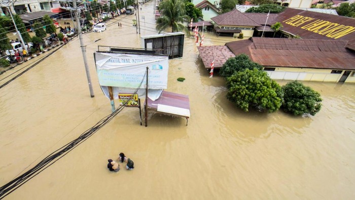 14 Kecamatan di Aceh Utara Terendam Banjir Sejumlah warga berjalan menembus banjir yang melanda Kota Lhoksukon, Aceh Utara, Aceh, Senin (3/1/2022). Data dari Badan Penanggulangan Bencana Daerah (BPBD) Aceh Utara mencatat banjir yang merendam 14 Kecamatan di daerah tersebut mengakibatkan 2.278 jiwa terdampak dan satu orang anak meninggal dunia. ANTARA FOTO/Rahmad