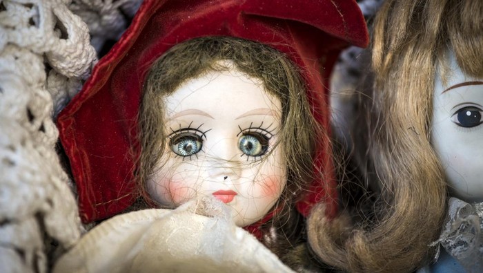 Scary antique doll and puppets in flea market