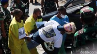 Tersangka memperagakan saat menggotong Handi Saputra dan Salsabila ke dalam mobil berpelat nomor B-300-Q.