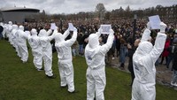 Sebagian peserta aksi hadir dengan mengenakan baju hazmat. Aksi ini untuk memprotes aturan pembatasan terkait virus Corona.