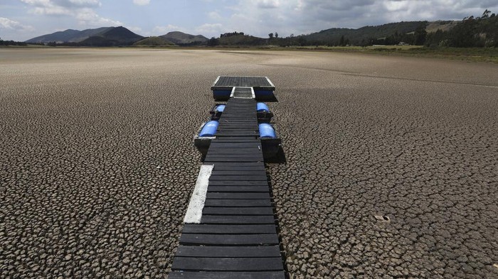 Fenomena Perubahan Iklim, Bumi Semakin di Ujung Tanduk A floating dock sits on the lakebed of the Suesca lagoon, in Suesca, Colombia, Wednesday, Feb. 17, 2021. The lagoon, a popular tourist destination near Bogota that has no tributaries and depends on rain runoff, has radically decreased its water surface due to years of severe droughts in the area and the deforestation and erosion of its surroundings. (AP Photo/Fernando Vergara)