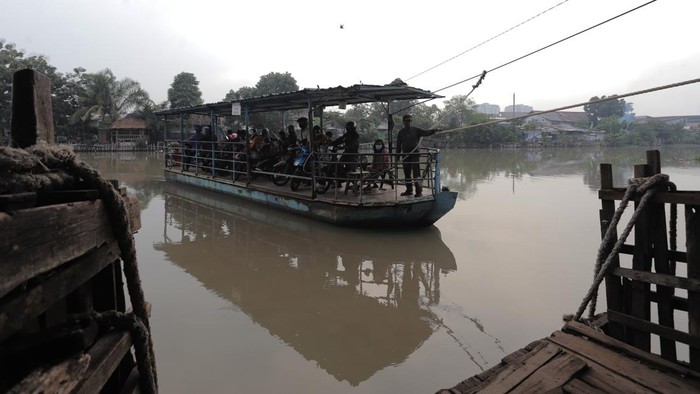 Sejumlah warga bersama kendaraannya berada di atas perahu ketika menyeberangi Sungai Brantas, Surabaya, Jawa Timur, Senin (3/1/2021). Sebagian warga mulai kembali beraktivitas setelah libur Tahun Baru dan perahu penyeberangan tersebut menjadi pilihan bagi mereka yang akan menuju ke Surabaya dari Sidoarjo atau pun sebaliknya karena lebih efesien dan untuk menghindari kemacetan. ANTARA FOTO/Rizal Hanafi/Zk/aww.