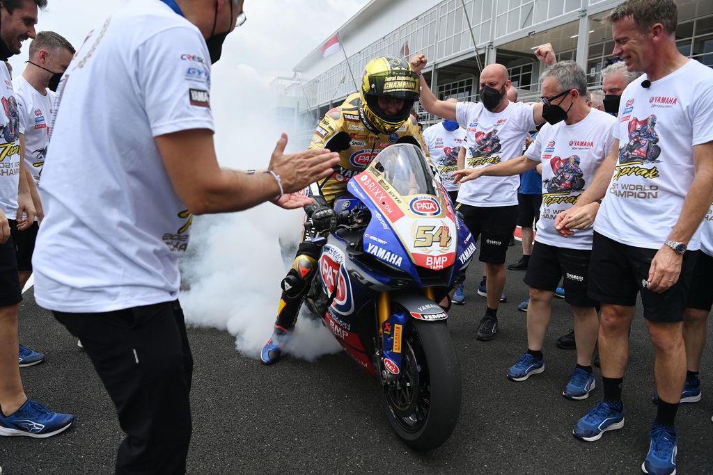 Pembalap tim Pata Yamaha With Brixx WorldSBK Toprak Razgatlioglu melakukan burnout disaksikan kru timnya usai memastikan meraih gelar Juara Dunia WSBK 2021 di Pertamina Mandalika International Street Circuit.