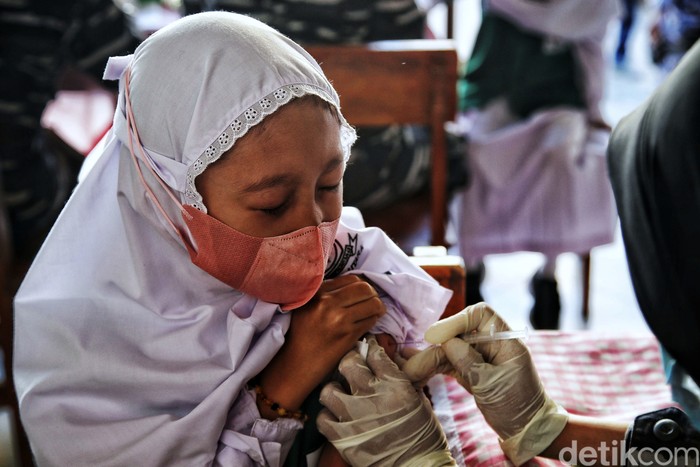 Prajurit Korps Wanita TNI AL memberikan vaksin Sinovac dosis pertama kepada anak-anak di kawasan Madrasah Al Wathoniyah 43, Rorotan, Jakarta Utara, Senin (3/12). Kegiatan tersebut merupakan gerakan serbuan vaksin TNI AL.