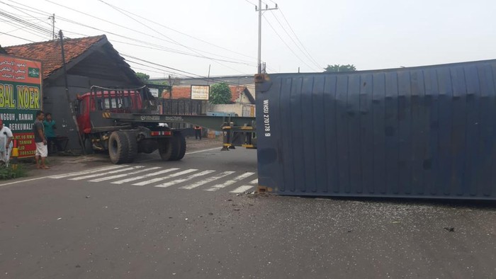 Truk trailer yang membawa kontainer terguling di traffic light simpang tiga Jalan Geluran, Taman, Sidoarjo. Truk terguling setelah mengalami rem blong.