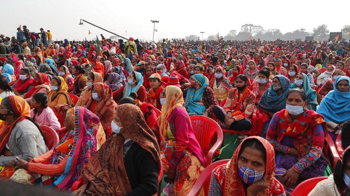 Tumpah Ruah Warga India di Tengah Lonjakan Omicron Women wearing face masks as a precaution against the coronavirus gather to listen to Indian Prime Minister Narendra Modi as he lays the foundation stone of Major Dhyan Chand Sports University in Meerut, Uttar Pradesh state, Sunday, Jan.2, 2022. India’s latest numbers of new COVID-19 cases show a worrying rise in infections and various states have brought in a slew of restrictions to curb cases. India’s Election Commission has decided to go ahead with legislature elections early this year in the country’s most populous state with over 200 million people. (AP Photo/Rajesh Kumar Singh)