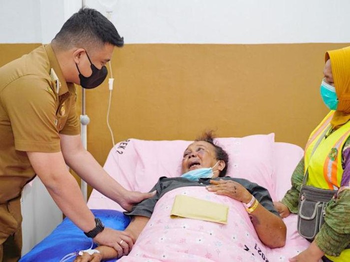 Wali Kota Medan Bobby Nasution (kiri) ketika menjenguk Ramadhoni Hasibuan, penyapu jalan menjadi korban begal di RSUD dr Pirngadi Medan, Senin (3/1/2022).  (ANTARA/HO-Diskominfo Kota Medan)
