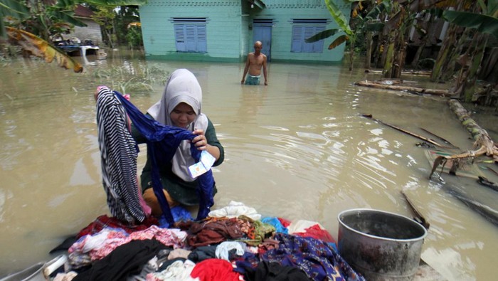 BANJIR DI ACEH UTARA Warga mengangkut pakaian yang terendam banjir ke depan rumah di Desa Meunasah Nga, Lhoksukon, Aceh Utara, Aceh, Selasa (4/1/2022). Data terakhir Badan Penanggulangan Bencana Daerah (BPBD) setempat menyebutkan banjir masih melanda 14 Kecamatan dan jumlah pengungsi terdampak bertambah dari 6.633 Kepala Keluarga (KK) atau 24.332 jiwa menjadi 9.766 KK atau 32.854 jiwa. ANTARA FOTO/Rahmad/tom.