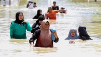 Warga berjalan menerobos banjir di Lhoksukon, Aceh Utara, Aceh, Selasa (4/1/2022).
