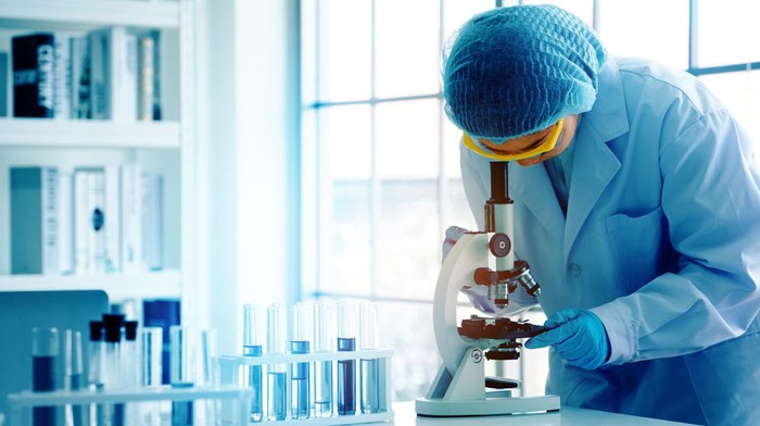 Asian scientist or doctors use microscopes to test for the coronavirus (COVID 19). Or a new flu virus to save human life In the lab Or hospital. Successful in researching the treatment of patients