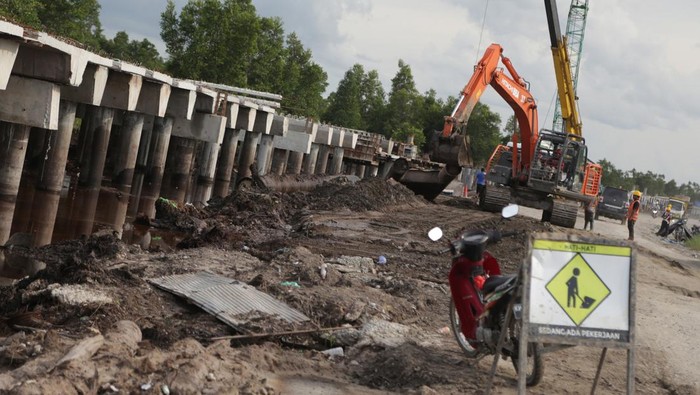 Pekerja mengoperasikan alat berat pada proyek pembangunan jembatan layang (pile slab) di Jalan Trans Kalimantan Bukit Rawi, Pulang Pisau, Kalimantan Tengah, Selasa (4/1/2022). Pemerintah Provinsi Kalteng membangun jembatan layang sepanjang 3,1 kilometer di ruas Jalan Trans Kalimantan poros tengah tersebut untuk mengantisipasi gangguan lalul intas akibat banjir tahunan dan ditargetkan selesai pada pertengahan tahun 2022. ANTARA FOTO/Makna Zaezar/tom.